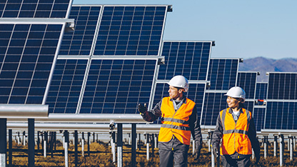 Experts with PPE at solar panel array