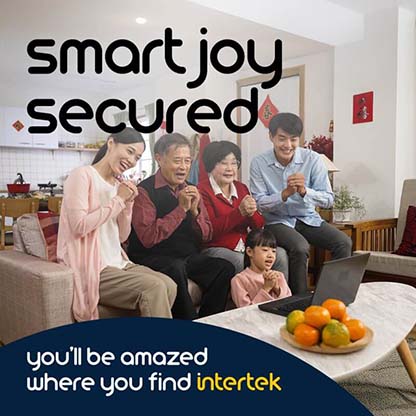 A family smiling and gesturing with clasped hands while seated in front of a laptop