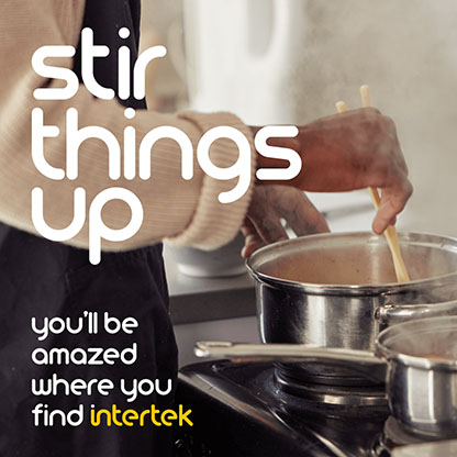 A cook stirring the contents of a pot on a stove